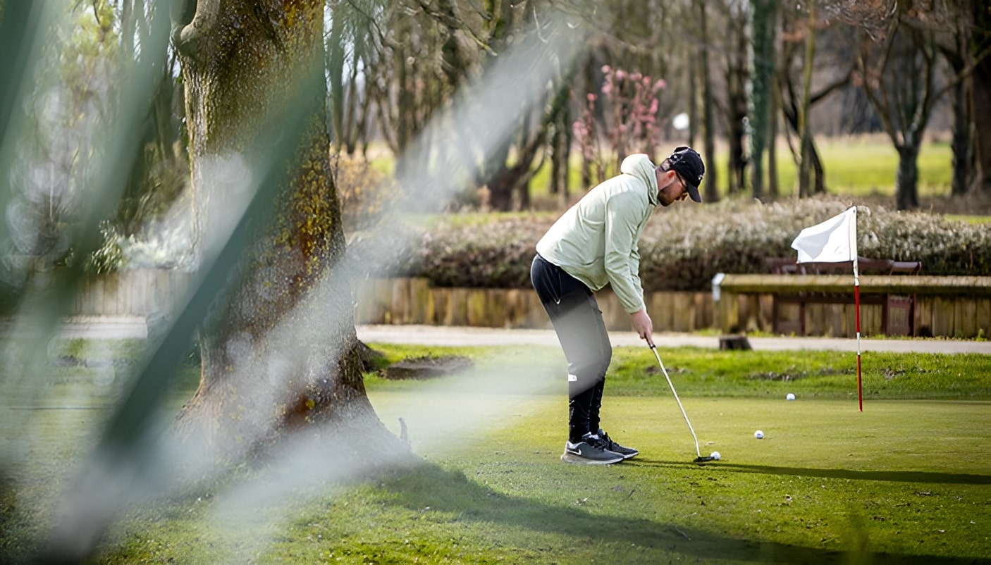 Man near a tree lining up shot for golf